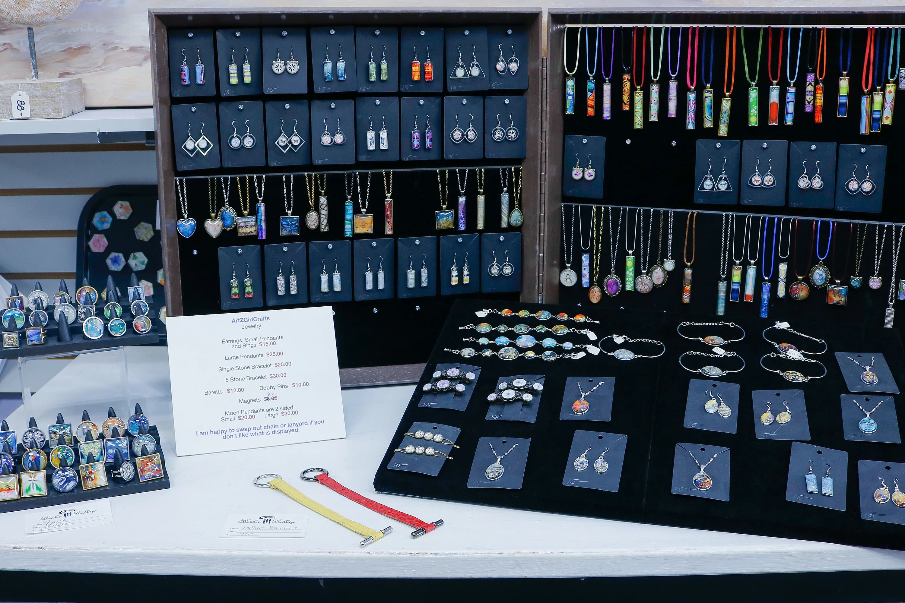 Display case of handmade pendants, earrings, and necklaces at Harbor Gallery