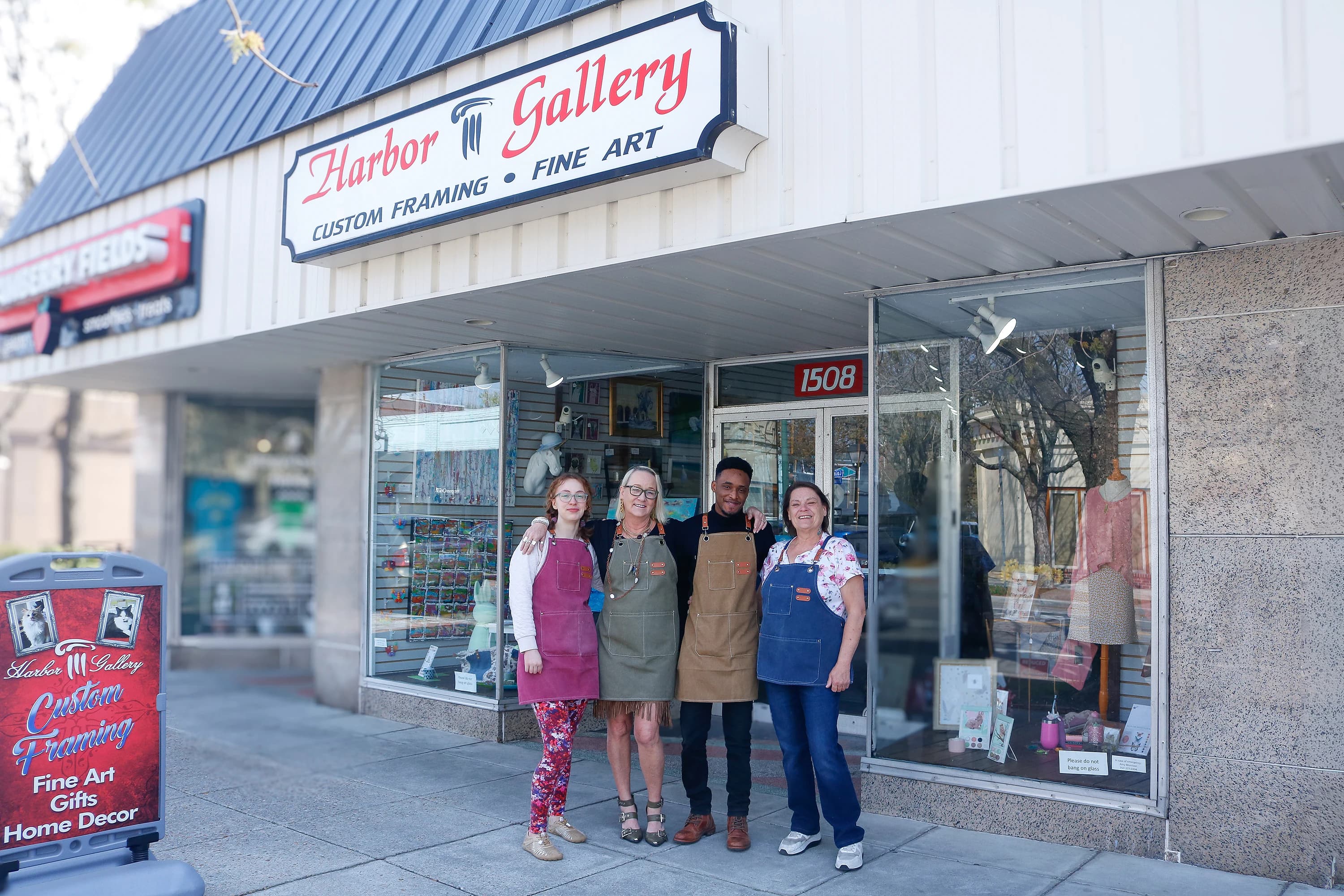 Four Harbor Gallery staff members outside the storefront on Colley Avenue